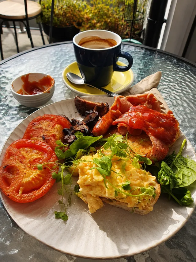 A breakfast plate and coffee in the sunlight